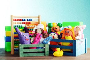 Spielerisches Lernen Bunte Handpuppen und Quietscheentchen vor einem Rechenschieber und Bauklötzen.